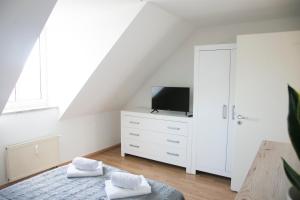 Un dormitorio con una cómoda blanca con TV. en CityOase Magdeburg im Hansapark, Studio 1, Tiefgarage, Netflix, Wi-Fi, Balkon, en Magdeburgo