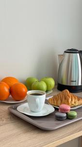 a table with a cup of coffee and fruit on it at Отель ЭРА in Almaty