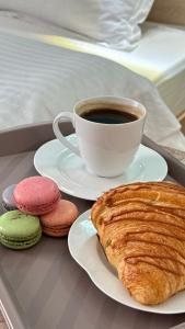 a cup of coffee and a plate with a pastry and cookies at Отель ЭРА in Almaty