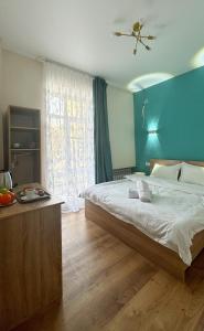 a bedroom with a large bed with a blue wall at Отель ЭРА in Almaty