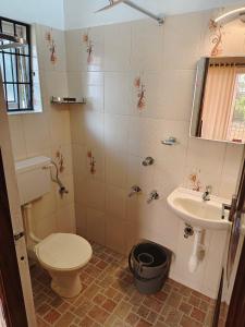 a bathroom with a toilet and a sink at Timber Monk Beach Resort in Pallipuram