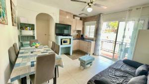 a kitchen and dining room with a table and a television at MEDDAYS APARTAMENTO MONTEMAR in Miami Platja