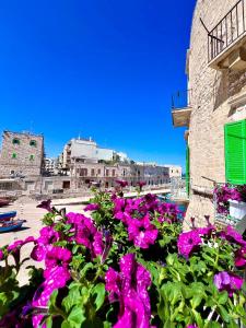 a bunch of purple flowers in front of a building at Torrione Apartment in Giovinazzo