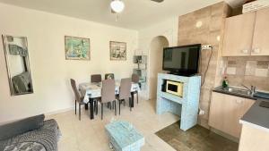 a kitchen and dining room with a table and a television at MEDDAYS APARTAMENTO MONTEMAR in Miami Platja