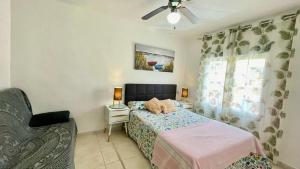 a bedroom with a bed and a chair and a window at MEDDAYS APARTAMENTO MONTEMAR in Miami Platja