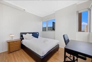 1 dormitorio con cama, escritorio y piano en Sky View 2B1B@burwood en Sídney