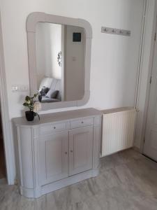 La salle de bains est pourvue d'une coiffeuse blanche et d'un miroir. dans l'établissement Light and sea 2, à Kavala