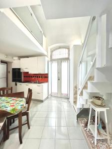 a kitchen and dining room with white cabinets and a table at Torrione Apartment in Giovinazzo