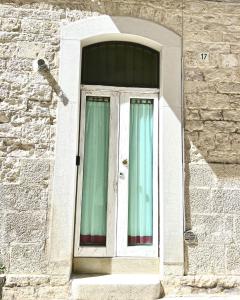 a window in a brick building with green curtains at Torrione Apartment in Giovinazzo