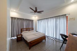 a bedroom with a bed and a ceiling fan at WINTEL WILD in Vālpārai