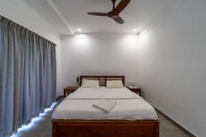 a bedroom with a bed with a ceiling fan at WINTEL WILD in Vālpārai