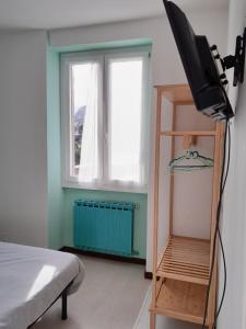 een kamer met een televisie, een bed en een raam bij Locanda dei pescatori in Domaso