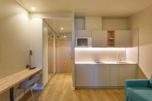 a small kitchen with a sink and a microwave at Hotel Landaben in Pamplona