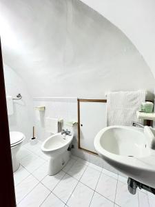 a white bathroom with a sink and a toilet at Torrione Apartment in Giovinazzo