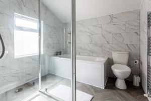 biała łazienka z wanną i toaletą w obiekcie Homey and Spacious 3 BR house for large group w mieście Blythe