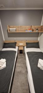a room with two beds and a desk and shelves at Mobile Homes Albatross in Jezera