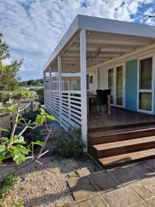 a house with a wooden deck with a table at Mobile Homes Albatross in Jezera