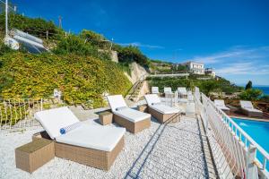 una fila di sedie a sdraio poste sopra un balcone di Villa Venera - pool, jacuzzi & breathtaking view a Maiori