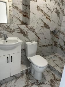Łazienka z białą toaletą i umywalką w obiekcie Отель ЭРА w mieście Ałma-Ata