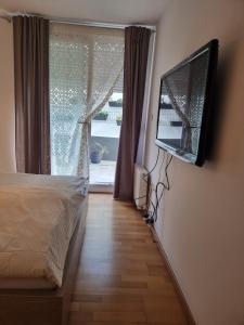 - une chambre avec un lit et une télévision murale dans l'établissement HIDDEN GEM Ljubljana, à Ljubljana