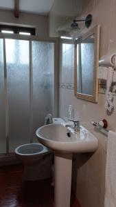 a bathroom with a sink and a toilet and a mirror at MRZ rentals LA CASINA in Cudillero