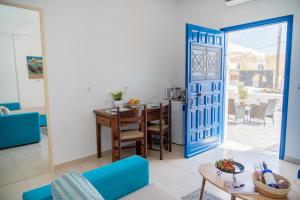 a living room with a table and a blue door at Rosalia Studio Megalochori in Megalokhori