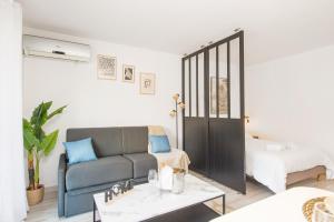 een woonkamer met een bank en een bed bij 5 mn à pied Monaco - Cosy appartement in Beausoleil