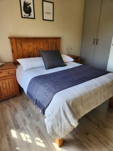 a bedroom with a large bed with a blue blanket at Habitat Place in Bloemfontein
