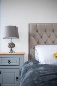 a bedroom with a bed with a lamp on a nightstand at New studio balcony apartment in Sheffield in Sheffield