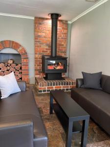 a living room with a brick fireplace and a couch at Grampians Park Station in Moyston