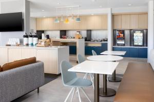a kitchen with two tables and a couch and a counter at TownePlace Suites by Marriott Pleasanton in Pleasanton