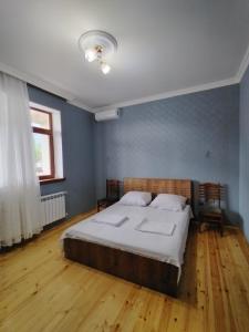 een slaapkamer met een groot bed en een houten vloer bij Rashid in Gabala