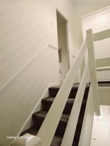 a staircase in a home with white walls and carpet at Prince's room in Dublin