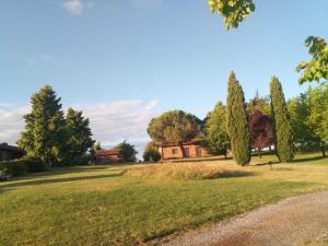 un parque con árboles y una casa en la distancia en Bicoca - Casaletti en Viterbo