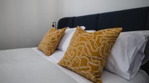 a bed with three pillows on top of it at Central Perk in Syracuse