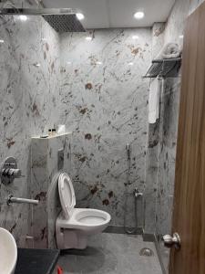 uma casa de banho com um WC branco e um chuveiro em Hotel Obsidian Red em Gorakhpur