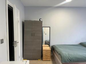 a bedroom with a bed and a dresser and a mirror at Sterne Street 4 Person Room in London +2 photos