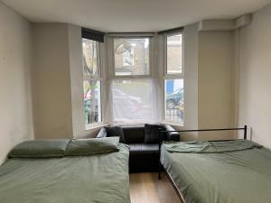 sala de estar con 2 camas y sofá en Sterne Street 4 Person Room, en Londres