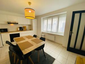 - une cuisine et une salle à manger avec une table et des chaises dans l'établissement Appartement Confortable - Trignac Centre Ville, à Trignac
