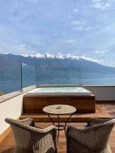 a balcony with a table and two chairs and mountains at Residence Dalco Suites & Apartments in Limone sul Garda