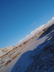 una sombra de una persona en una montaña cubierta de nieve en Kush, en Kochkorka