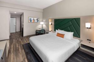 een slaapkamer met een groot bed en een groene muur bij Wingate by Wyndham Sulphur Near Lake Charles in Sulphur