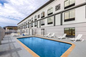 a swimming pool in front of a building at Wingate by Wyndham Sulphur Near Lake Charles in Sulphur
