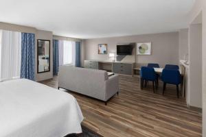 een hotelkamer met een bed, een bank en een bureau bij Wingate by Wyndham Sulphur Near Lake Charles in Sulphur