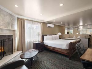 ラスベガスにあるDays Inn by Wyndham Las Vegas Airport Near the Stripのベッドと暖炉のあるホテルの部屋