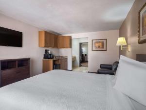 Habitación de hotel con cama y sala de estar. en Travelodge by Wyndham Tucson AZ, en Tucson