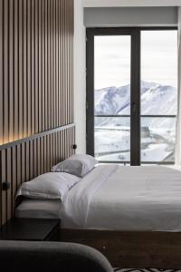 a bedroom with a bed and a large window at New Gudauri View Hotel in Gudauri