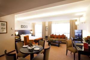 a hotel room with a living and dining room at Ramada Plaza by Wyndham Beirut Raouche in Beirut