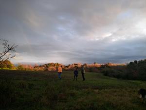 Tre persone che camminano in un campo con un cane di Bicoca - Casaletti a Viterbo