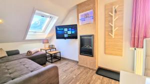 a living room with a couch and a flat screen tv at Ferienwohnung-Allgaeu-Pfronten -Inkl KönigsCard Fewo BREITENBERG in Pfronten